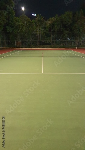 A close up photo of green tennis court with white line © Marlon Hutajulu