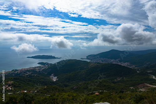 View from the mountains to the city of Budva in Montenegro. Panorama of the Adriatic coast and green mountains.