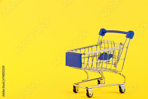 Empty mini shopping trolley, Shopping cart, on a yellow background. RFI Request for information. copy space