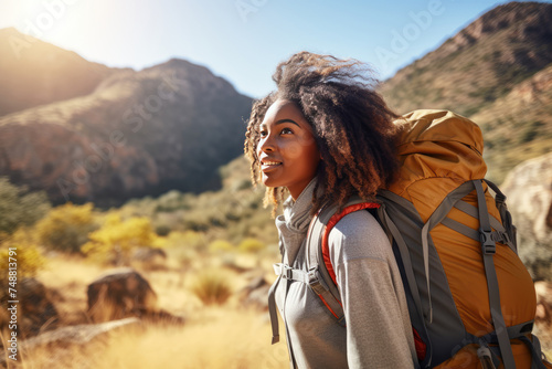 Young african woman in hiking gear on the mountain in a sunny day