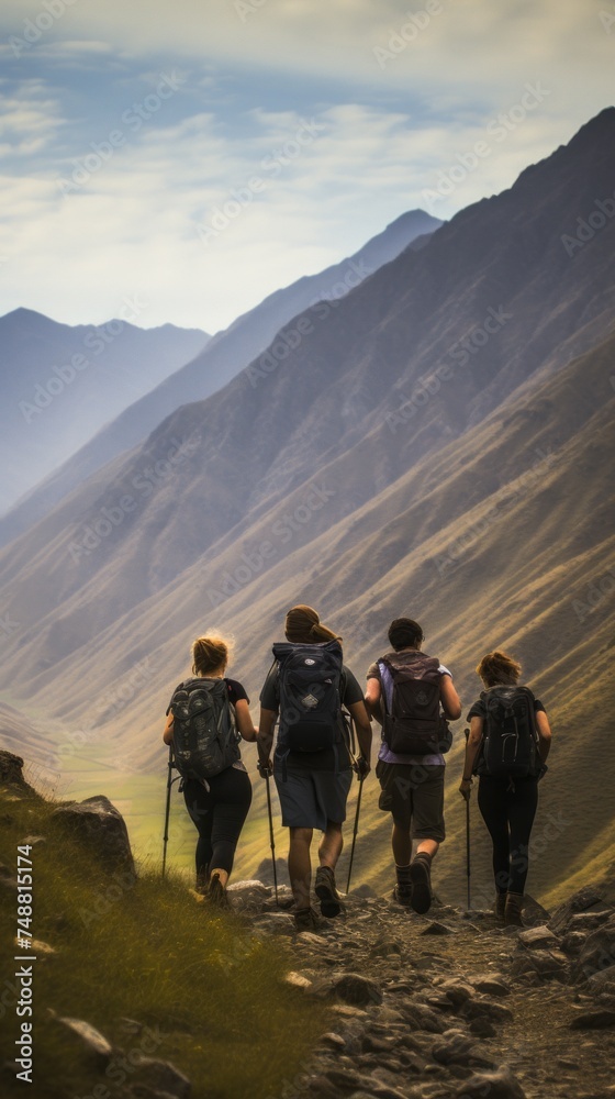Rear view of a group of Friends, young Men and Women hiking in the Mountains. Travel, Adventure, Active Tourism, Hiking, Summer Vacations, concepts. Vertical photo.