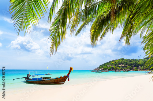 Coconut palm trees and long tail boat on white sand tropical beach in Koh Tao island, Surat Thani Province, Thailand.