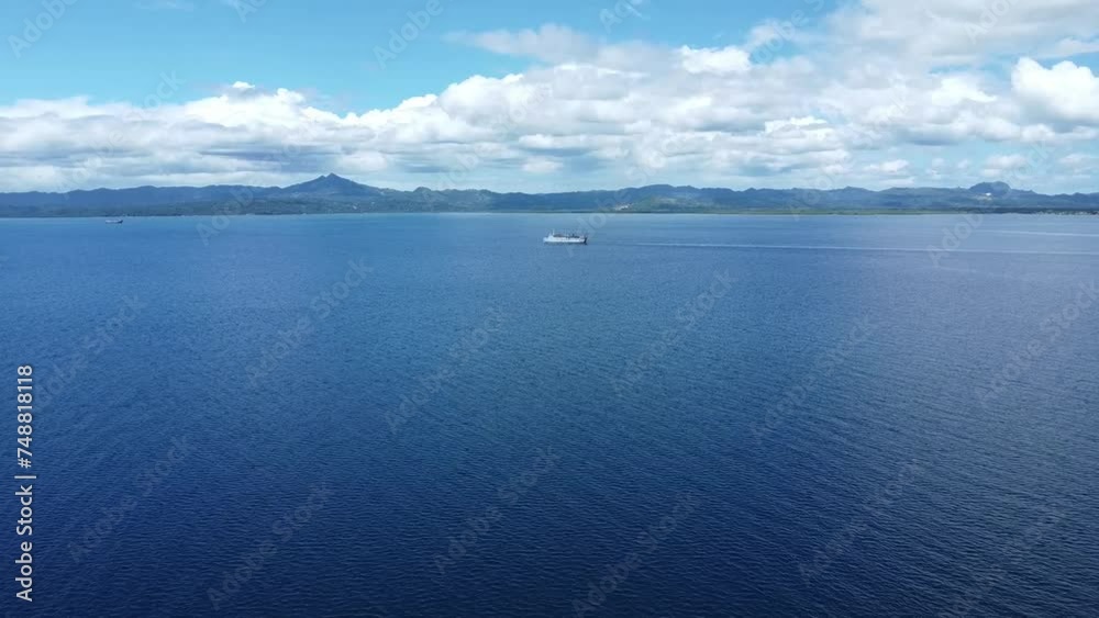 a passenger ship sails on the sea against the backdrop of mountains, aerial view. a passenger ship sails on the sea against the backdrop of mountains, aerial view.
