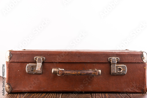 Old suitcase on the table against white background.