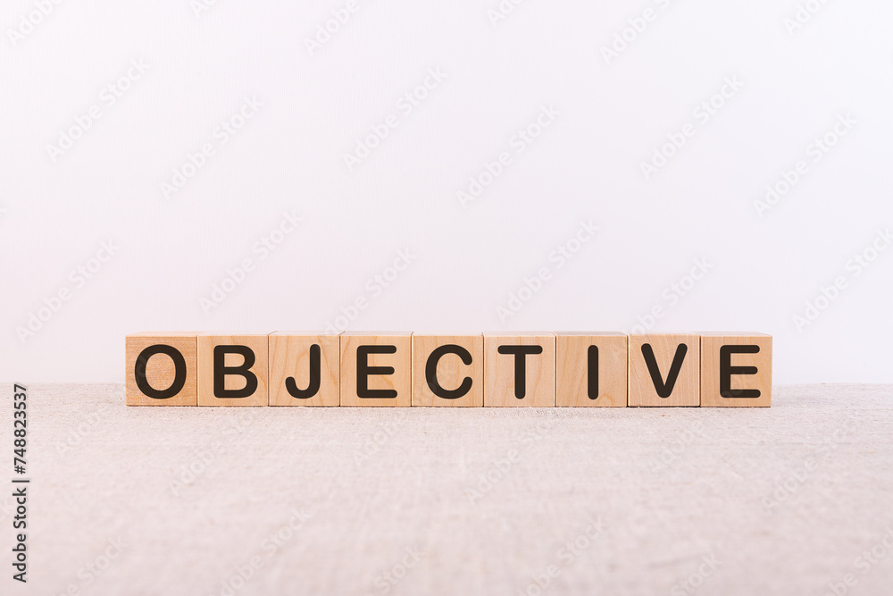 Fototapeta premium ObjectiveOBJECTIVE word concept written on wooden cubes lying on a light table and light background.