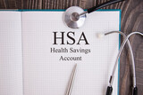 Page with, HSA, Health Savings Account on the table with stethoscope, medical concept
