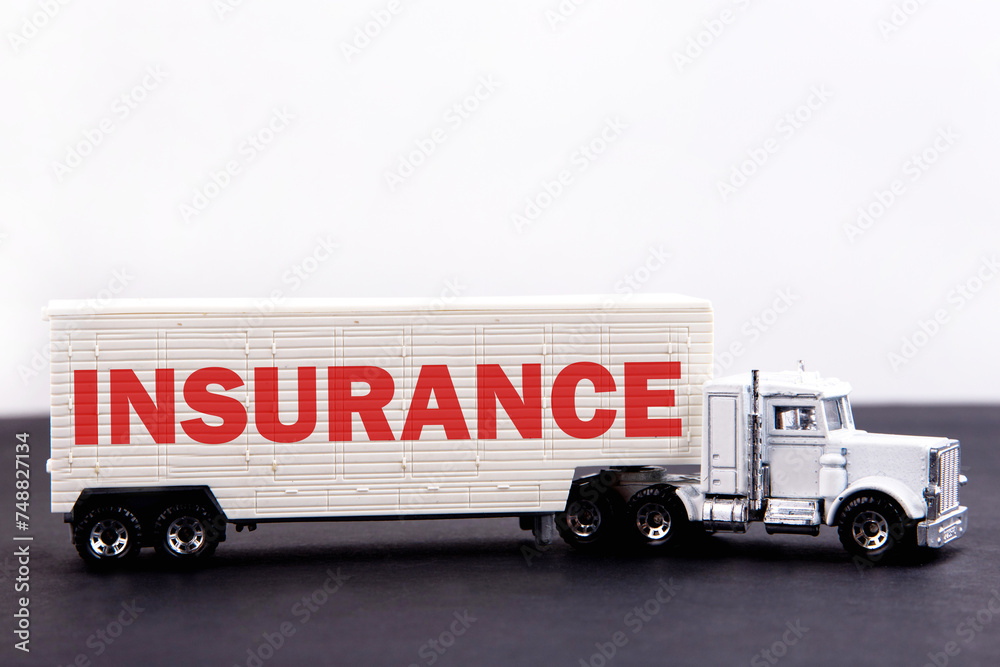 Insurance word concept written on board a lorry trailer on a dark table and light background Insurance word concept written on board a lorry trailer on a dark table and light background