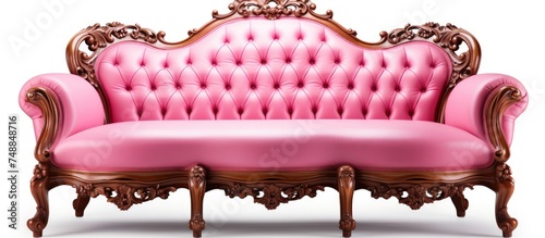A pink classical leather sofa is placed on top of a beautifully carved wooden frame. The contrast between the pink color and the wooden texture creates an interesting visual appeal. photo