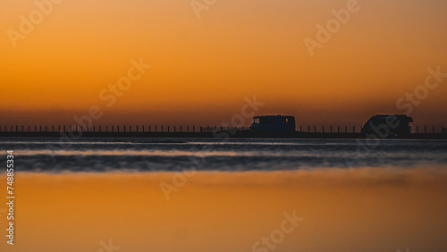 Obraz na płótnie Lever de soleil sur une plage de Camarague avec deux camions aménagés w salonie