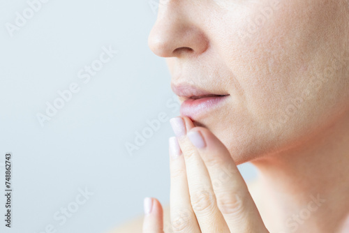 Woman gently touching her lips. Woman with nasolabial wrinkles, problem dry skin and with big pores on the face. Nutrition of the skin. photo