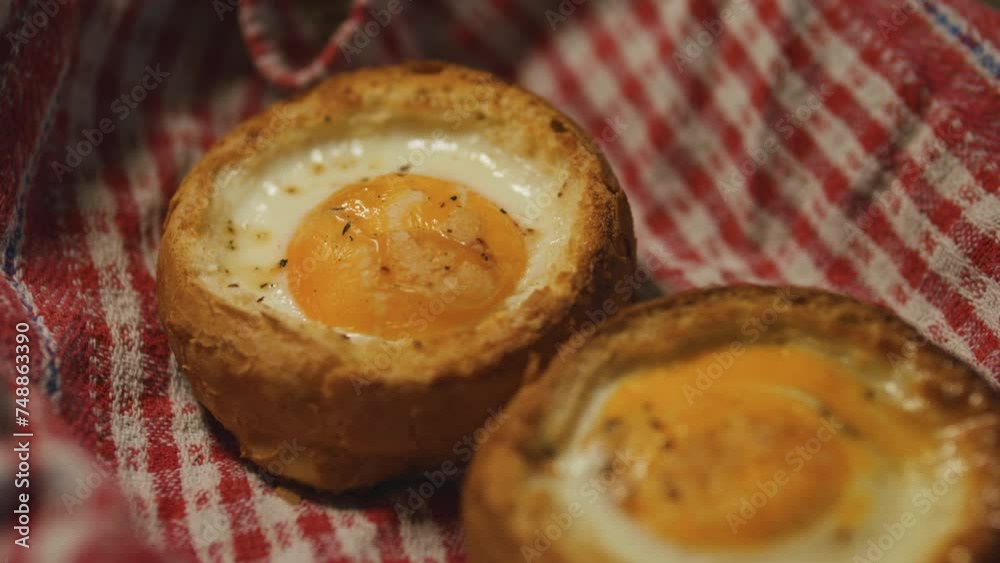 Oven baked eggs in buns. Fried eggs in bread on a rustic towel. Oven baked eggs in buns. Fried eggs in bread on a rustic towel.