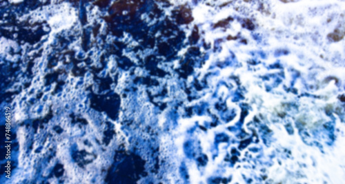 Seething foamy waves, water surface in blur, out of focus, sea, ocean or background, texture.