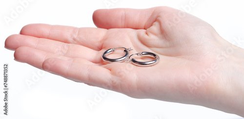 Jewelry silver earrings in hand on white background isolation