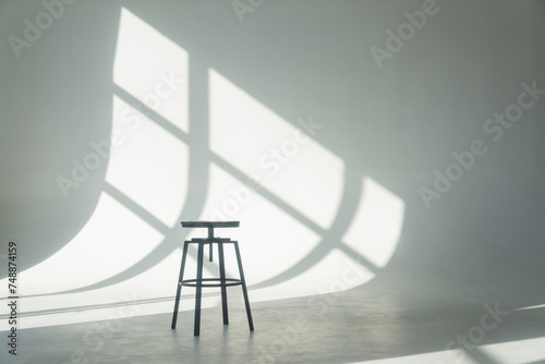 Bar stool on a white cyclorama with reflections from the window.