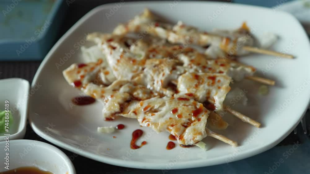 Teriyaki chicken skewers on plate at restaurant, slow motion shot at 30 fps Teriyaki chicken skewers on plate at restaurant, slow motion shot at 30 fps