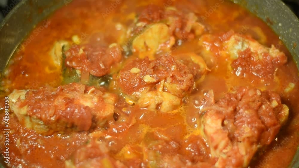 The video shows how tomato sauce is boiling in a frying pan in which pieces of fish are stewed. The video shows how tomato sauce is boiling in a frying pan in which pieces of fish are stewed.