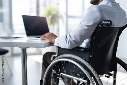 physically disabled person sits in a wheelchair and works in the office. Disabled people with disabilities can work like normal people.