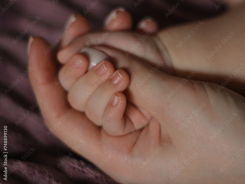 newborn's hand in mother's hand
