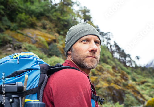 Portrait of caucasian man with backpack in Makalu Barun Park route near Khare. Mera peak climbing acclimatization active walk. Backpacker enjoying valley view. Active people concept