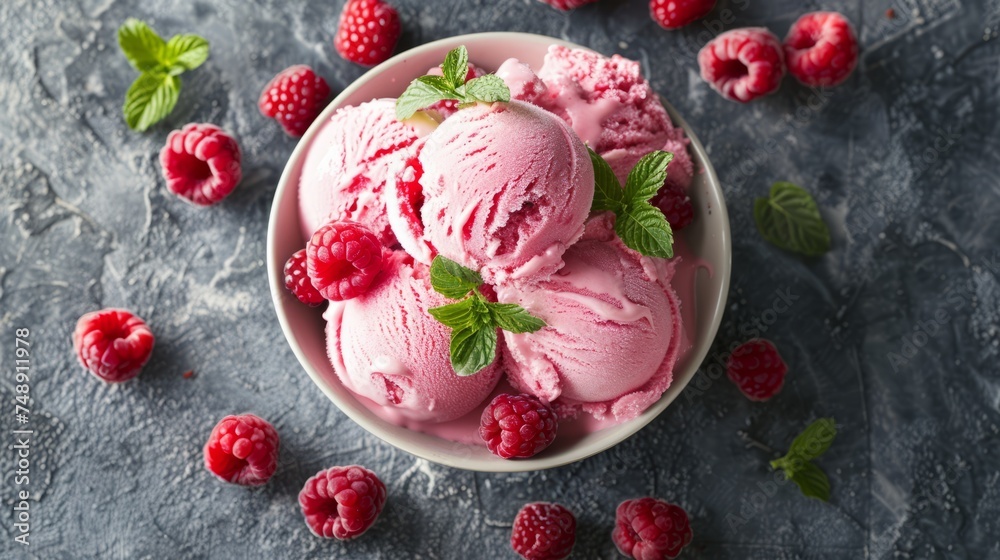 a bowl of raspberry flavored ice cream topped with fresh raspberries and raspberry leaves on a dark textured surface a bowl of raspberry flavored ice cream topped with fresh raspberries and raspberry leaves on a dark textured surface