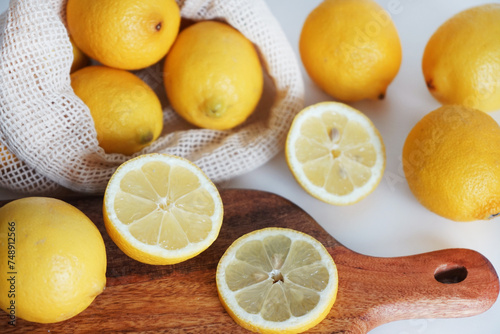 Whole and sliced       lemons on a wooden board on a light background