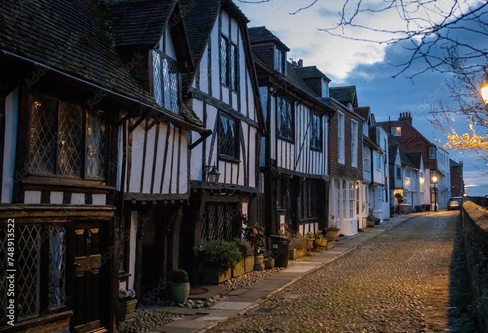 Old town cobbled street and historic houses in Rye during a sunset on a cloudy day