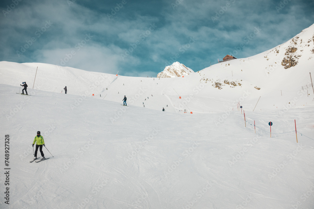 Ski resort in winter Alps. Skiers ride down the slope. Tux, Hintertux, Austria.