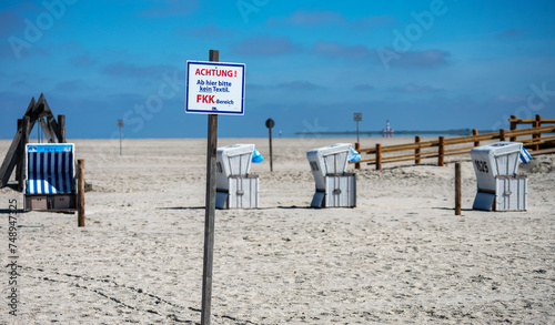 Strandkörbe und Hinweisschilder am Sandstrand der Nordsee, Sankt-Peter-Ording, Schleswig-Holstein, Deutschland photo