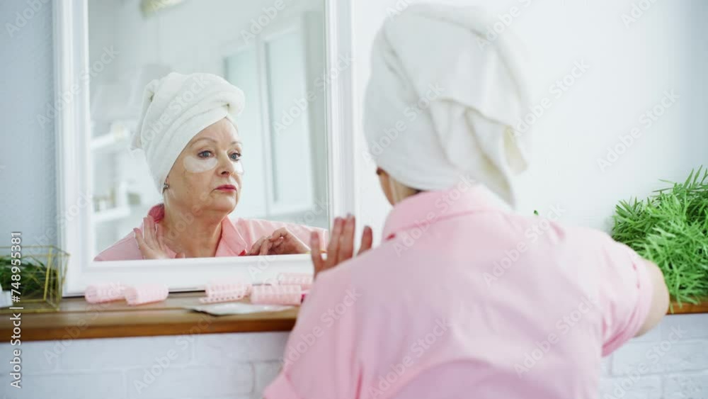 Elderly woman taking care of her facial skin Elderly woman taking care of her facial skin