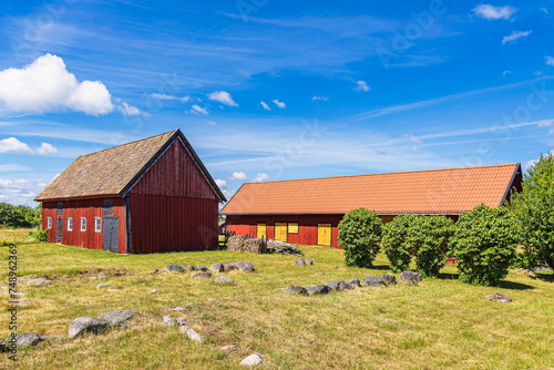 Rote Holzhäuser und Bäume auf der Insel Sladö in Schweden