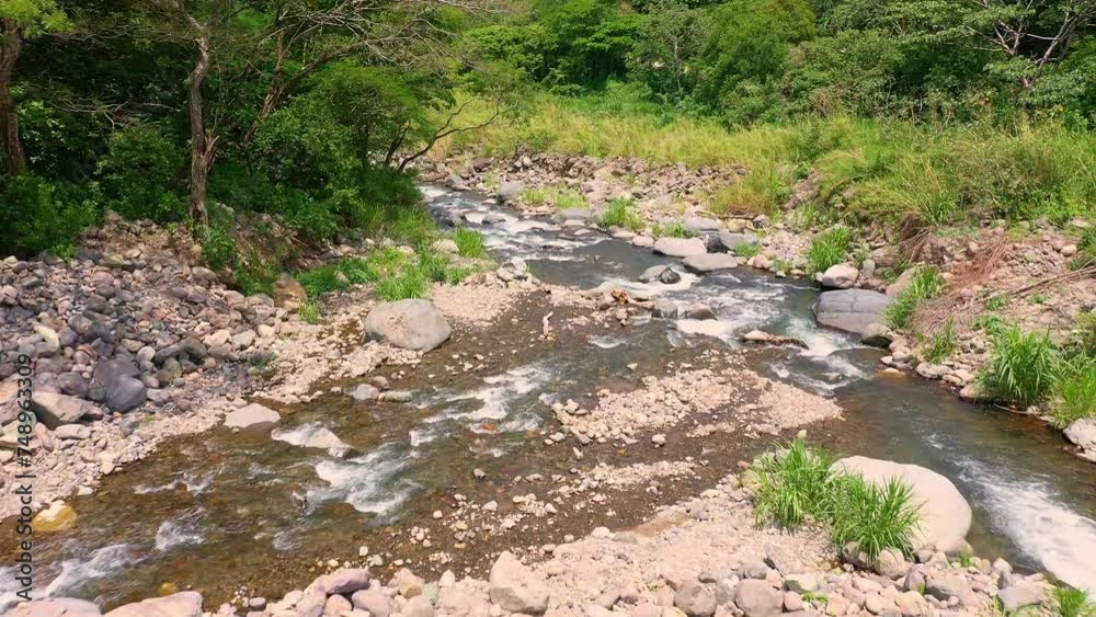 Shallow, clean river amidst rocky terrain in a green forest, dolly out Shallow, clean river amidst rocky terrain in a green forest, dolly out