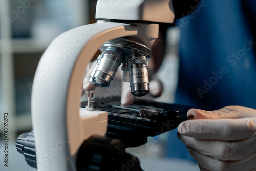 close-up in veterinary clinic the doctor puts a piece of glass under a microscope