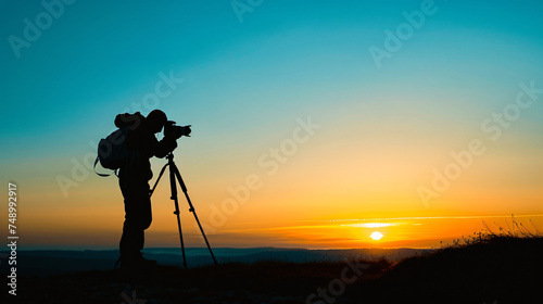 A silhouette of a photographer capturing the sunrise.