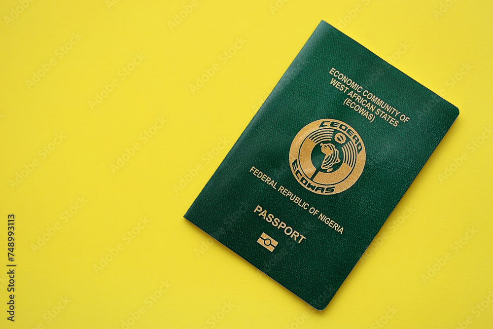 Green Nigerian passport on yellow background close up. Tourism and citizenship concept Green Nigerian passport on yellow background close up. Tourism and citizenship concept