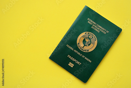 Green Nigerian passport on yellow background close up. Tourism and citizenship concept photo