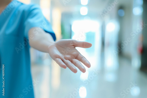 Unrecognizable nurse reaching out a hand to help you in the hospital. Close up image, selective focus