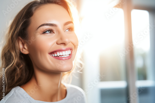  A joyful young woman admires her perfect teeth in a dentist's office mirror, exuding happiness and confidence. © Natalia Aguiar