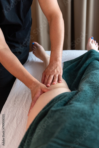 Sports massage. Massage therapist massaging legs of an athlete in health, beauty salon, spa. Concept: relaxing, healthy, acupressure treatment. Self care, me time, enjoying time, perfect gift.