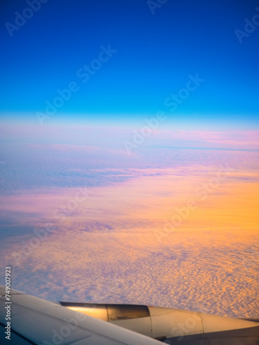 Cloudscape and blue sky at sunset, a view through the airplane window over Seoul Incheon International Airport, South Korea, a tranquil high altitude scenery © Naya Na