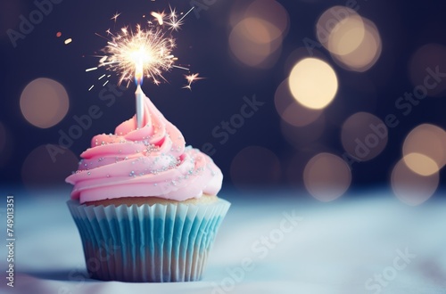 a pink cupcake with a candle in front of sparklers
