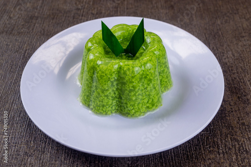 pudding lumut or moss pudding served on a white plate with pandan leaves on top. Very fresh and healthy food photo