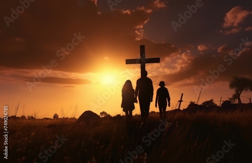 silhouette of a family walking through the field, with an empty cross in the ...