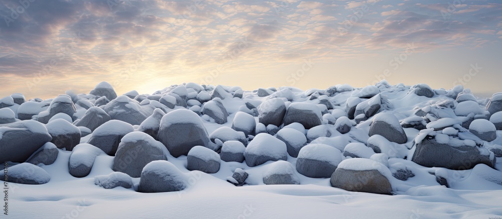 A substantial accumulation of rocks, topped with a thick layer of snow, creating a stark contrast. The rocks are protruding through the snow, forming an intriguing pattern against the white background A substantial accumulation of rocks, topped with a thick layer of snow, creating a stark contrast. The rocks are protruding through the snow, forming an intriguing pattern against the white background
