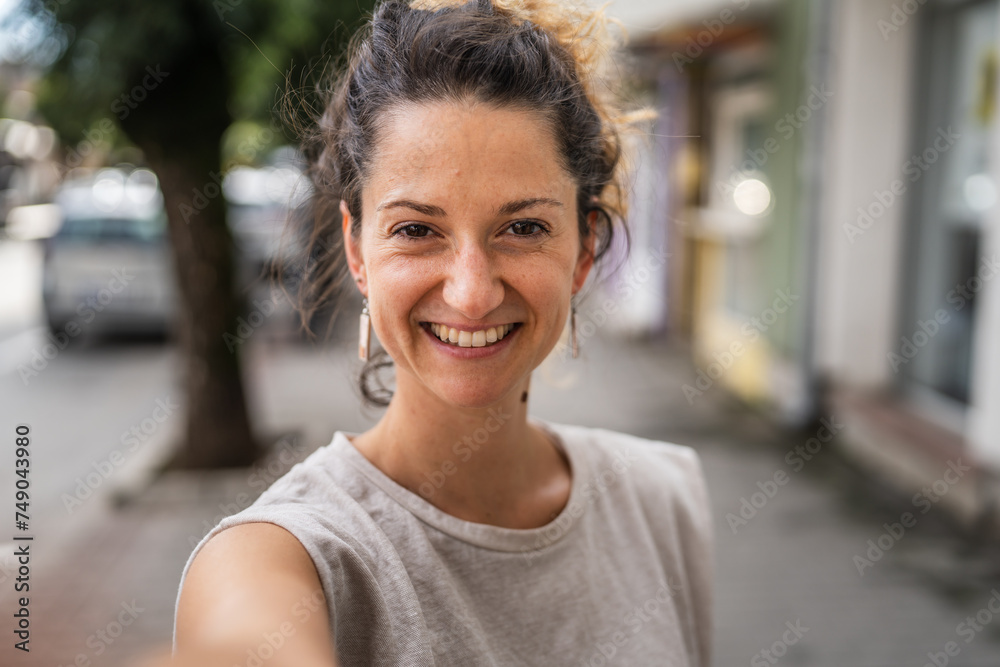Portrait of adult caucasian woman stand in town or city outdoor in day