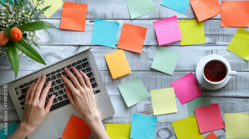 A womans hands typing on a laptop surrounded by colorful postit notes and a cup of tea representing a digital platform for organizing and promoting communityled health and photo