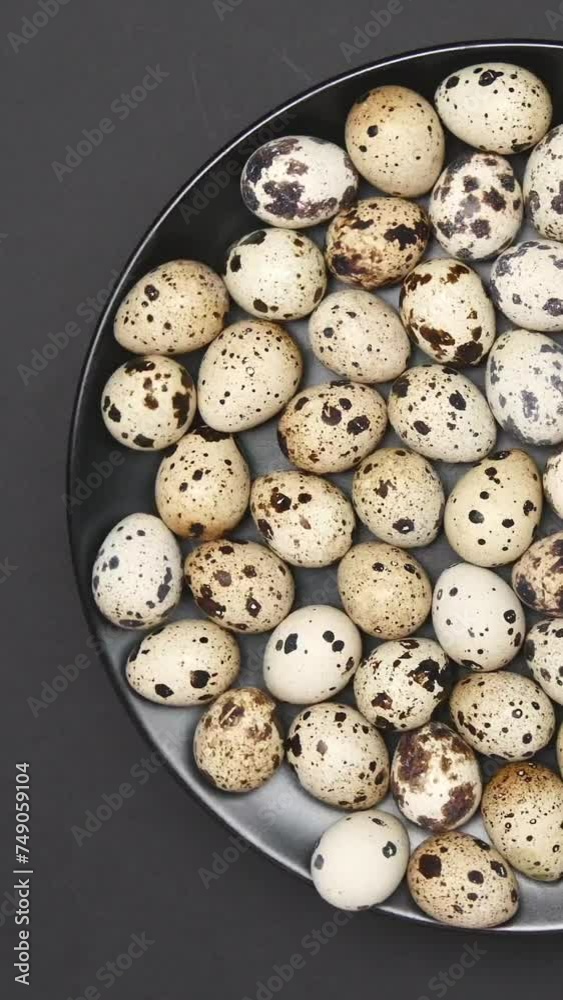 Rotating Quail Eggs On A Black Plate On A Black Background. Top View. Vertical. Rotating Quail Eggs On A Black Plate On A Black Background. Top View. Vertical.