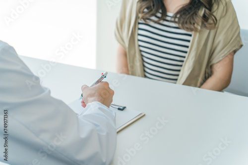 Foto 診察を受ける患者の女性と話を聞く医師・医者（婦人科・性病検査・性感染症・中絶）