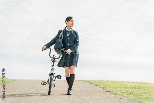 自転車で通学・登校・下校する制服姿の中学生・高校生（夢・希望・進路・道・将来・未来・青春・歩く）
 photo