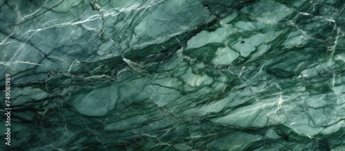 A detailed close-up of a green marble texture with intricate white curly veins. This surface showcases the unique patterns and colors of granite stone, ideal for ceramic wall tile and flooring designs