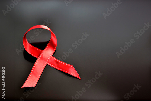 red ribbon in the shape of mourning on a black background